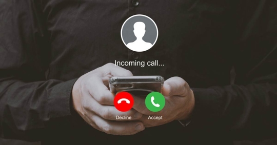 Man holding smartphone with incoming call interface screen
