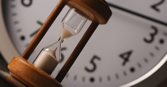 Wooden Hourglass with Clock Background - Emergency bankruptcy concept