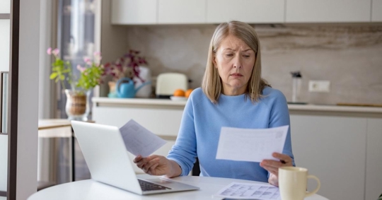Woman feeling financial stress while checking documents