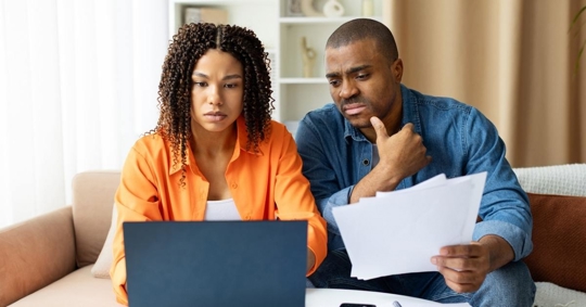 Two worried people reviewing a loan together