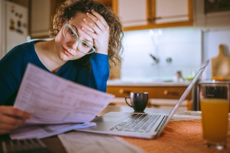 worried woman looking at bills