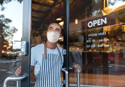 Man with mask opening his business