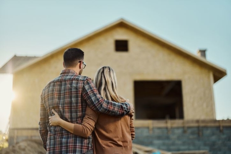 couple standing in front of house