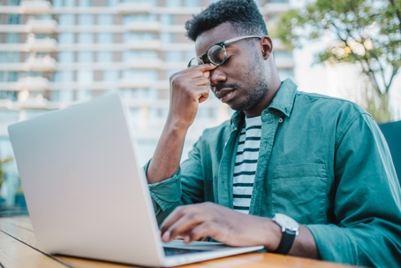 Stressed businessman using laptop.